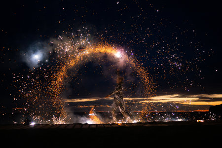 A girl lights a sparkler on the beach at duskの写真素材