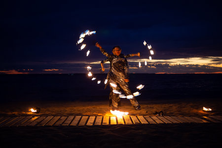 Two girls light a sparkler on the beach at duskの写真素材