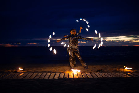 Two girls light a sparkler on the beach at duskの写真素材