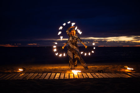 Two girls light a sparkler on the beach at duskの写真素材