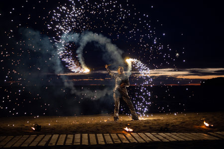 A girl lights a sparkler on the beach at duskの写真素材