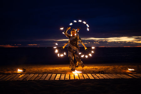 Two girls light a sparkler on the beach at duskの写真素材