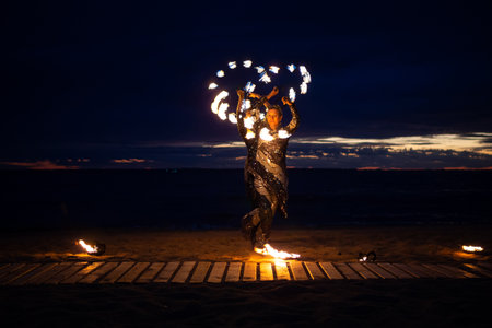 Two girls light a sparkler on the beach at duskの写真素材