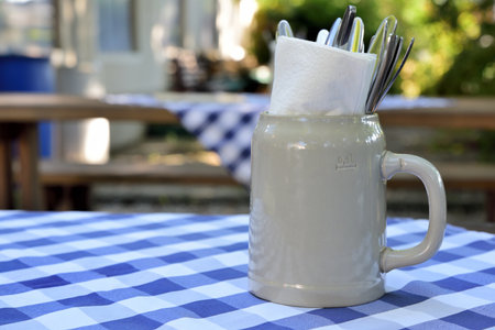 Closeup of a typical Bavarian stoneware beer mug standing decorative as a container for cutlery on a...