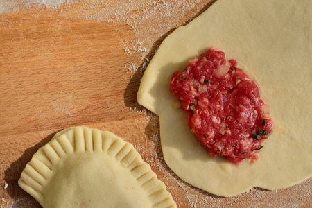 Top view of Russian cheboreki freshly prepared with batter and minced meat