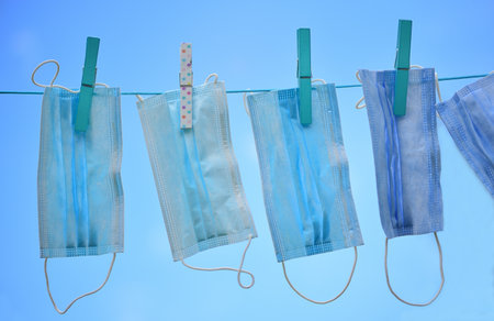 After a reprocessing, cleaned pulp muck guards hang on a clothesline against a blue sky