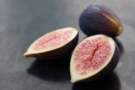 red sliced ââfresh figs lie next to each other, against a gray backgroundの写真素材