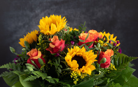 Close-up of a colorful fresh bouquet of roses and sunflowers, against a gray backgroundの写真素材