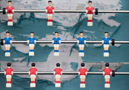 An old plastic football game with figures on sticks. The figures hang like puppets over the tattered and old football field. The game features two teams.の写真素材