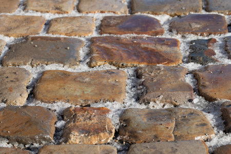 Cobblestone pavement photographed from diagonally above. There is snow in the joints. There is a danger of slipping.の写真素材