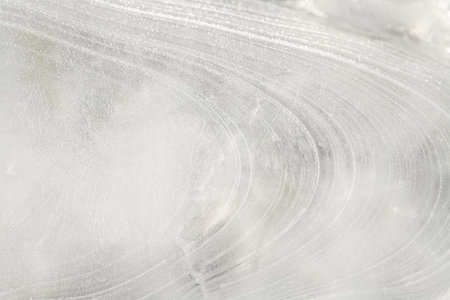 Close-up of fresh ice made from water. The ice was formed by rain and wind. It has many curves on the surface.の写真素材