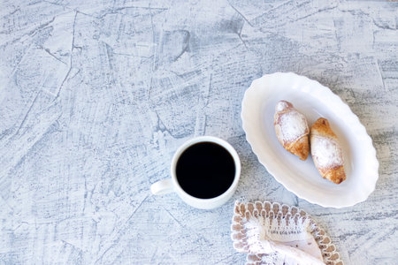 Italian breakfast with croissants and coffee. Two croissants and coffee served with napkin on...