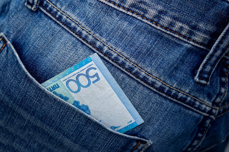 Kazakhstani tenge in the back pocket of jeans. Five hundred tenge in a denim pocket. Close-upの写真素材
