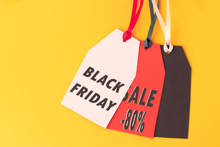 Three paper labels with the text black Friday sale written in it against a yellow background. Black Friday concept. Copy space.の写真素材