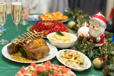 A festive table with many delicious dishes. Lamb rack, two glasses of champagne, salads and snacks on the festive table. Celebrations at home.の写真素材