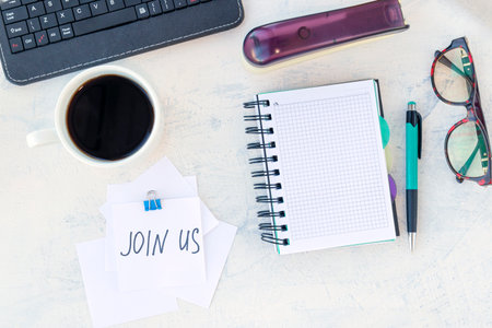 Join us. Job recruiting concept. Words Join us in a note on the working table. Top view.の写真素材