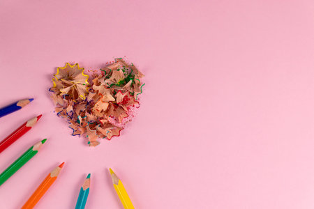 Sharpened colored pencils and heart-shaped pencil shavings on pastel pink color. Rainbow or LGBT pencils. Decoration for St. Valentine's Day. Top viewの写真素材