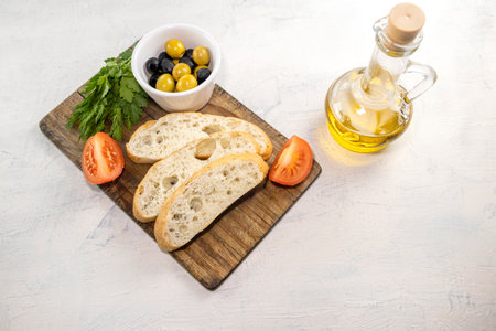 Fresh, tasty option for serving Italian focaccia. Sliced bread on serving board served with olives,...