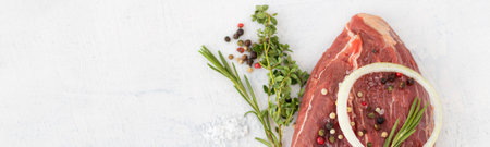 Banner with beef, onion, mixed pepper, salt, thyme, rosemary. Raw, fresh beef meat with spices on a white stone background. Top view. Copy spaceの写真素材
