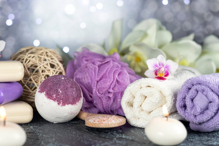 Bath bomb, orchid flowers, burning candles, towel, soap, washcloths, combs, abstract lights Spa resort therapy composition Soft focusの写真素材