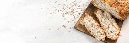 Banner with siced bread on serving board with flax and sunflower seeds. Fresh, tasty, round wheat...