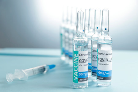 Covid-19 Corona Virus 2019-ncov vaccine vials medicine drug bottles syringe injection blue nitrile surgical gloves. Vaccination, immunization, treatment to cure Covid 19 Corona Virus infection Conceptの写真素材