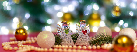 Banner with Two angels with blur white Christmas balls and Christmas beads on bokeh background. Christmas background or Christmas card. New Year or Xmas concept. Copy space. Soft focusの写真素材