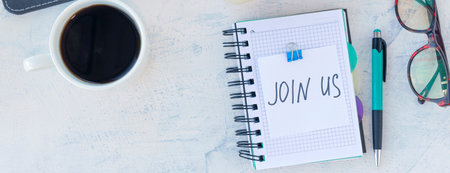 banner with Join us. Job recruiting concept. Words Join us in sticker on the working table with cup of coffee. Top view.の写真素材