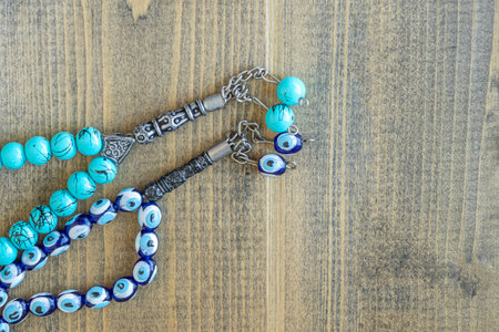 Two blue beads sequenced, short rosary on wooden table. tespih tesbih, an important accessory for Turkish culture. rosary beads Tasbih Islamic Muslim Stuff Prayers concept. Flat lay. copy spaceの写真素材