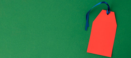 banner with One empty red tag on a green background. Copy space for your text. Black Friday concept.