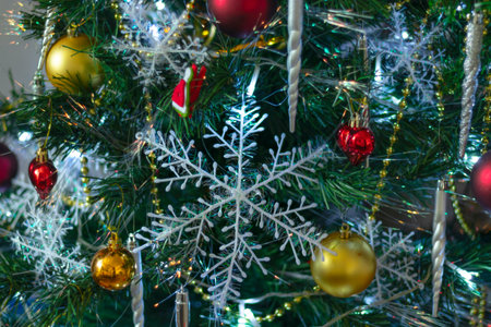 new year or xmas background with green christmas tree, white snowflakes, colorful toys and gold...