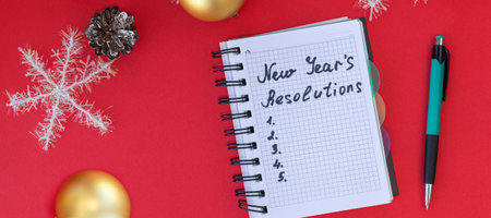 banner with New Year's resolutions on red background with snowflakes, Christmas balls, and pine cones. New Year's resolutions concept. Flat lay. Top viewの写真素材