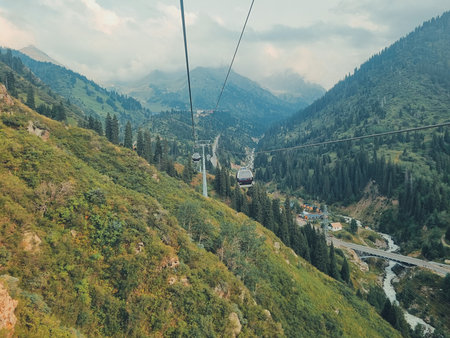 August 11, 2024, Almaty, Kazakhstan. a cable car moving through the green mountains between Medeu and Shymbulak under a clear sky, scenic and peaceful landscape.の写真素材
