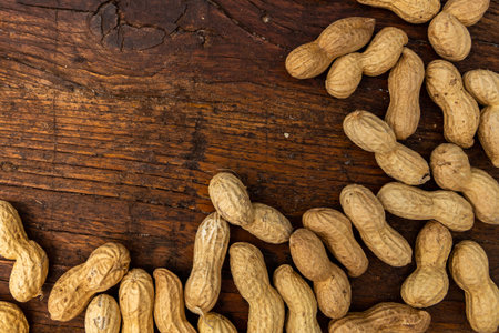 A lot of penuts on wooden background