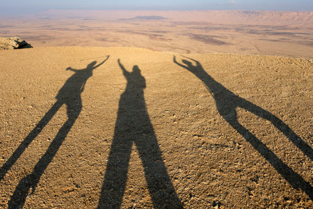 Three shadows of tourists in Negev desert, Israel.の写真素材