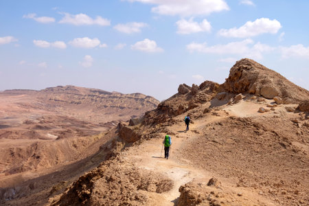 Unrecognized couple of hikers on scenic trail in Negev desert mountains, Israel.の写真素材