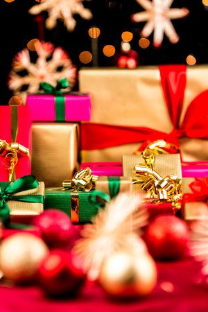 Plain Christmas gifts placed on a red cloth. All with bows and ribbons. Shallow depth of field....