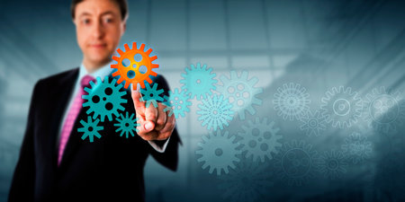 Happy businessman is touching a cog in a virtual gear train.の写真素材