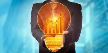 Unrecognizable manager offering a bright idea for sales growth in the shape of a lightbulb with a trend chart for glow wire. Business concept for corporate vision, forecasting, trending and success.の写真素材