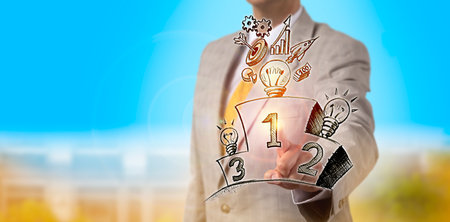 Unrecognizable businessman is picking the number one light bulb with the brightest business strategy among three standing on a winner podium in a sketch. Metaphor for inspiration and achievement.の写真素材