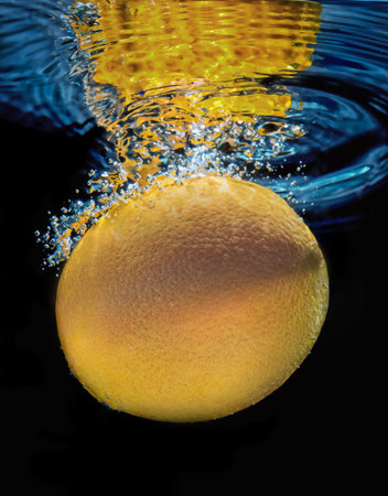 Orange Fruit Underwater with Waves and Bubbles on Black Backgroundの写真素材