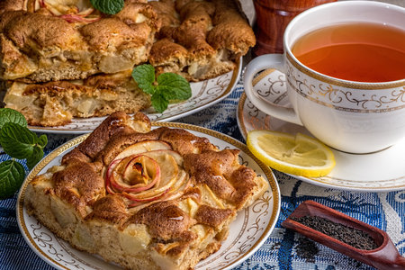 Tasty Apple Pie Piece on a Plate with a Cup of Tea, Lemon Slice and Mint Leavesの写真素材