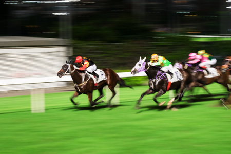 Racehorses ridden by jockeys running fast during the race at race course from start to finish. Striving to victory. Horizontal image, motion blur.の写真素材