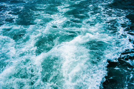 Dark blue sea foaming waves. Abstract textrured natural background with lot space for text. Template for design.の写真素材