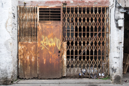 Closed old weathered rusty metal door in slum district.の写真素材