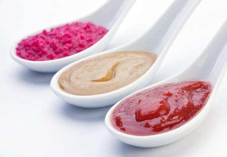 ketchup, mustard and horseradish in sauce spoon closeup on whiteの写真素材
