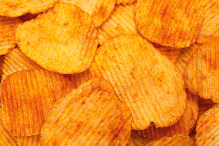Orange pepper potato chips closeup textured backgroundの写真素材