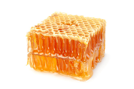 Yellow Honeycomb slice closeup isolated on white backgroundの写真素材