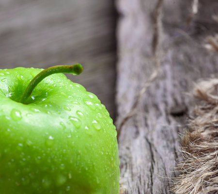 ripe green apples and apple slices on wooden gray backgroundの写真素材