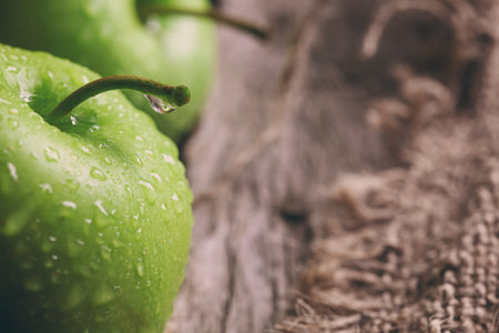 ripe green apples and apple slices on wooden gray backgroundの写真素材